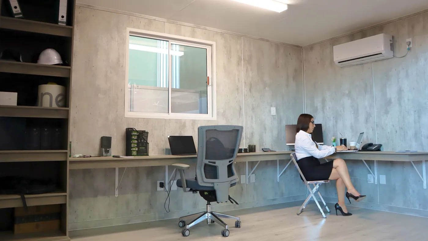 Inside a DBOX mobile office: desks, mini-split A/C and a full-length work bar
